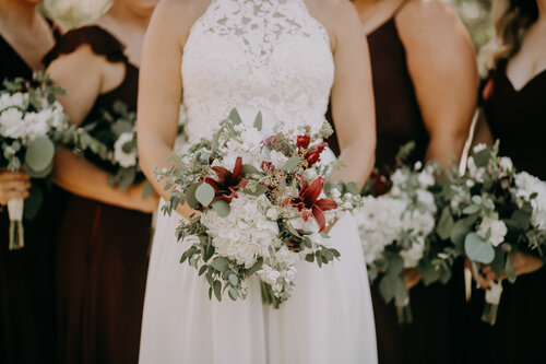 Bride holding flower hoop with bridesmaids