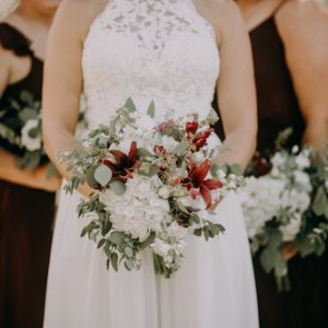 Bride holding flower hoop with bridesmaids